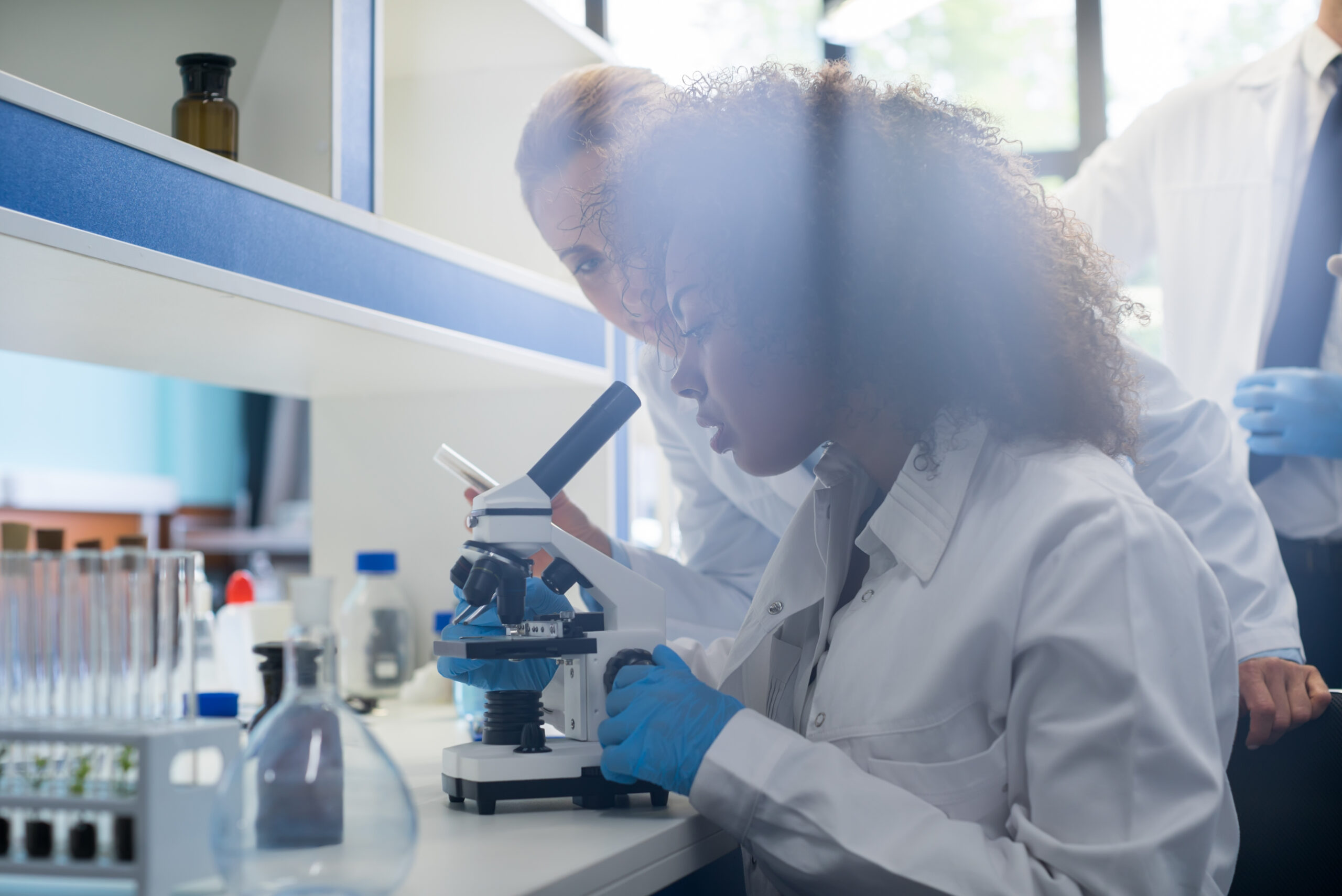 Male Scientist Working With Microscope, Team In Laboratory Doing Research, Man And Woman Making Scientific Experiments Doctors